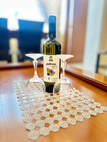 a bottle of wine and two glasses on a table at Family Beach apartment in Perea