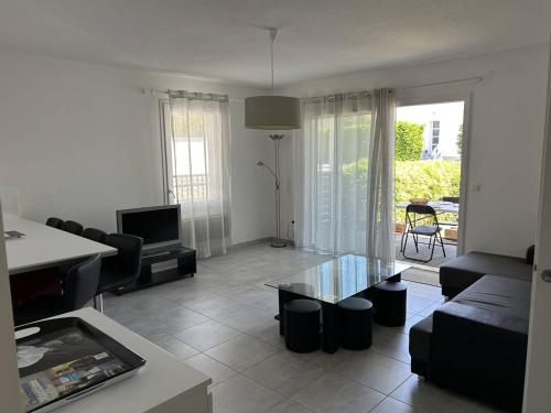 un salon avec un canapé et une table dans l'établissement Appartement T3 cosy avec jardin à deux pas du centre de Meschers, garage et animaux admis - FR-1-738-1, à Meschers-sur-Gironde