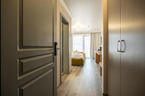 a room with a door and a bedroom with a bed at Novum Stay - Pensiune Centrala in Hunedoara in Hunedoara