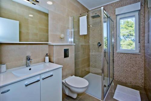 Un baño con inodoro, ducha y lavabo. en Island Hvar Villa LeChalet with Pool, en Bogomolje