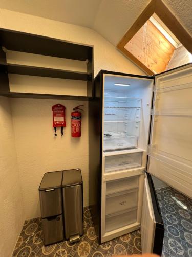a refrigerator with its door open in a room at Timos Dahoam 93qm Balkon und familienfreundlich in Nesselwang