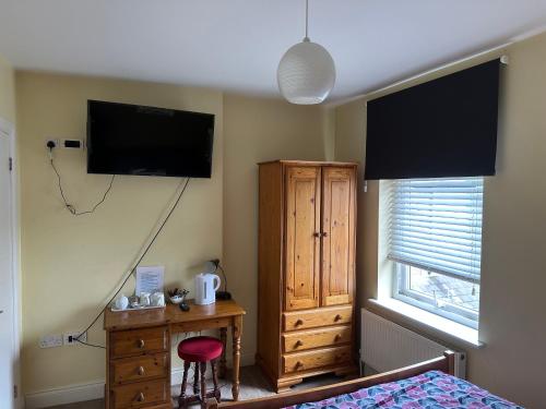 a bedroom with a tv and a dresser and a bed at 287 Green Lanes in London