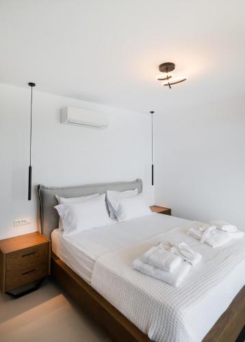 a bedroom with a bed with two towels on it at Azzura villas in Vasiliki