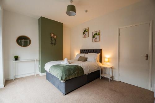 レッドカーにあるThe Alfred Suiteのベッドと緑の壁のある寝室