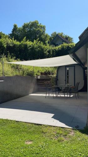 a patio with a table and chairs under a canopy at All inclusive Ferienhaus JULYN , Seepark in Kirchheim
