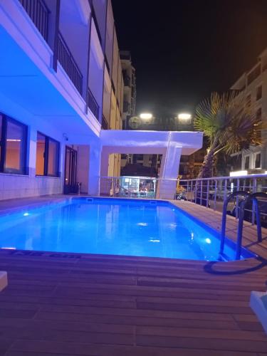 a swimming pool at night next to a building at Didim Altinkum Hotel in Didim