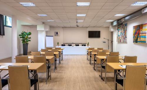 a classroom with tables and chairs in a room at iH Hotels Milano Gioia in Milan