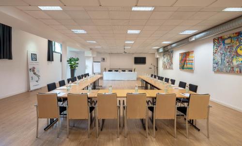 a conference room with a long table and chairs at iH Hotels Milano Gioia in Milan