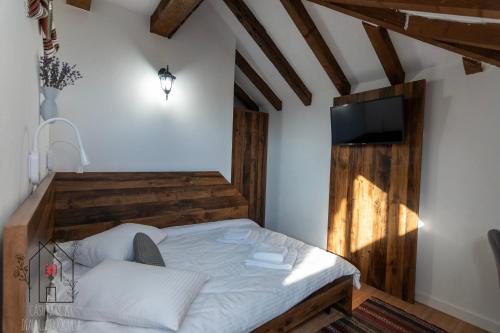 a bedroom with a bed and a flat screen tv at Casuta de pe dealul Cojocului in Runcu