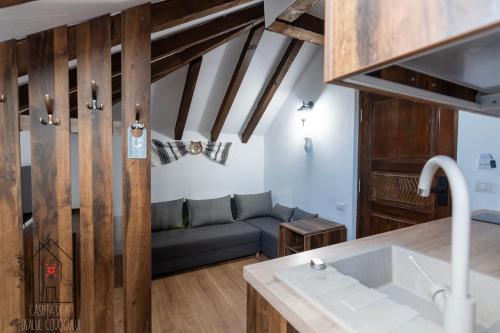 a kitchen and living room with a couch in a room at Casuta de pe dealul Cojocului in Runcu