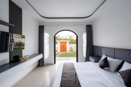 a bedroom with a bed and an open door at Majestic Balangan in Uluwatu