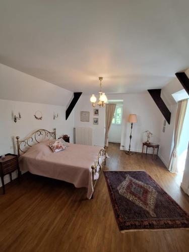a bedroom with a large bed and a rug at Le Manoir de la Feuillade in Carsac-Aillac