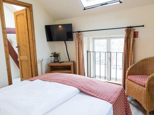 a bedroom with a bed and a tv and a window at Landhaus Alte Schmiede in Niemegk