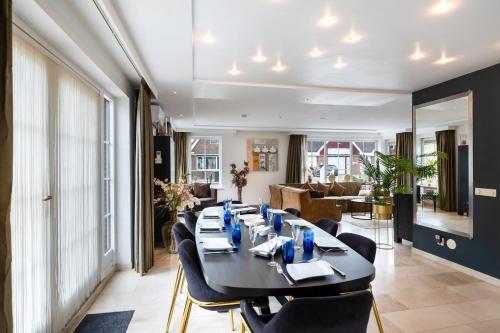 a dining room with a black table and chairs at Casa Grande - cityview Amsterdam in Landsmeer