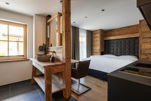 1 dormitorio con 1 cama y escritorio con fregadero en Das Denisl, en Reit im Winkl