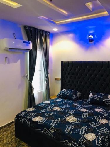 イバダンにあるAM Apartmentsの青い天井のベッドルーム1室