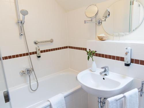a bathroom with a sink and a tub and a mirror at Landhaus Alte Schmiede in Niemegk