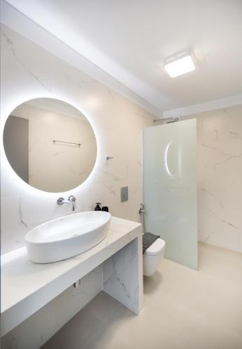 a white bathroom with a sink and a toilet at Azzura villas in Vasiliki