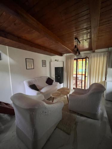 a living room with a white couch and chairs at Holiday Home UnaPark in Krakovo