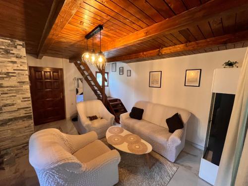 a living room with white furniture and a wooden ceiling at Holiday Home UnaPark in Krakovo