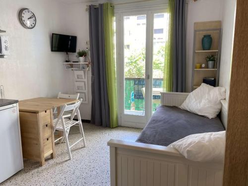 une chambre avec un lit et un bureau et une cuisine dans l'établissement Studio climatisé avec balcon proche centre et thermes, Balaruc-les-Bains - FR-1-553-21, à Balaruc-les-Bains