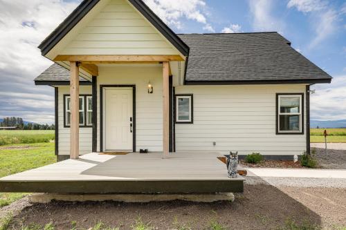 a small house with a cat sitting in front of it at Kalispell Mountain Getaway with Hot Tub and Fire Pit! in Kalispell