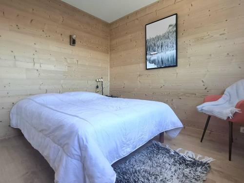 une chambre avec un lit blanc et une chaise dans l'établissement Appartement rénové 3 pièces avec terrasse, casier à skis et parking privé à Bolquère - FR-1-592-40, à Bolquère-Pyrénées 2000