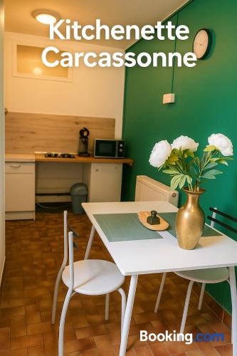 ein weißer Tisch und Stühle mit einer Vase mit Blumen in der Unterkunft Carcassonne Studio in Carcassonne