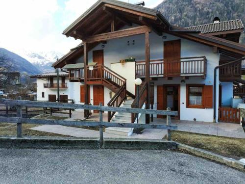 a house with a balcony and a table in front of it at Da Nadia a Ossana casetta in Val di Sole in Ossana