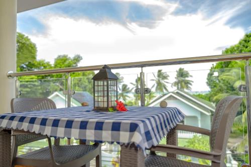 a table with a blue and white checkered table cloth at Praslin Orchid Villa in Grand Anse