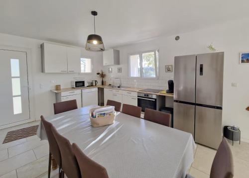 une cuisine blanche avec une table et un réfrigérateur dans l'établissement Bastide Tante Rose, au Muy