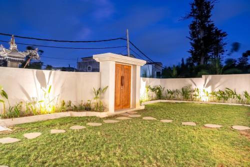 a house with a wooden door in a yard at Majestic Balangan in Uluwatu