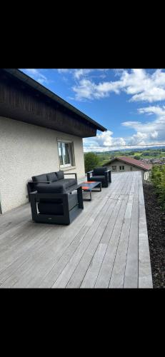 a wooden deck with two couches on top of a house at La Maison du Rond-Buisson in Maîche