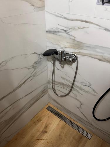 a shower in a bathroom with a marble wall at Holiday Home UnaPark in Krakovo