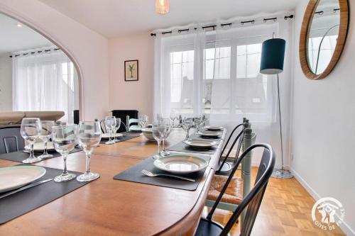 une salle à manger avec une table et des verres à vin dans l'établissement La maison d'anne-claire, à Ploemeur