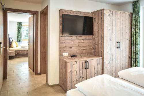 a bedroom with a tv on a wooden wall at Lisas Schröcken in Schröcken