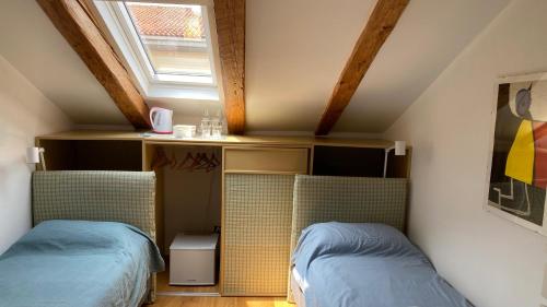 a attic room with two beds and a window at Alle scalette in Trieste