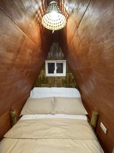 a bedroom with a bed in a wooden wall at Hill Top Residence in Sampong