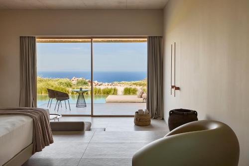 a bedroom with a bed and a view of the ocean at D3 Milos in Plaka Milou