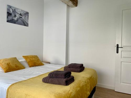 une chambre avec un lit avec deux serviettes dessus dans l'établissement La Maison d'Alcyone by Melrose, à Bayeux