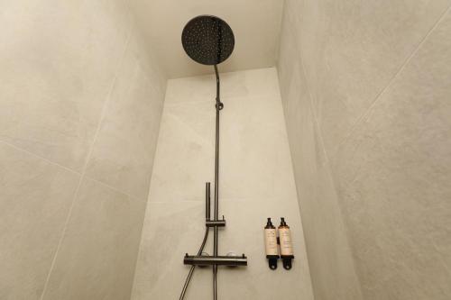 a shower with two shampoo bottles on the wall at Lodge met Jacuzzi - 4 personen - Woodz Lodges in Heusden - Zolder