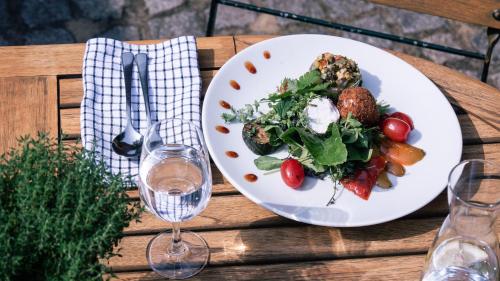 a table with a plate of food and a glass of wine at Landhaus Alte Schmiede in Niemegk