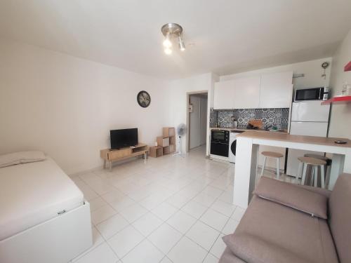 une cuisine et un salon avec une table et des chaises dans l'établissement Studio cosy au cœur de Toulon, à Toulon