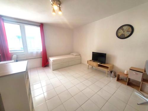 un grand salon avec une télévision et une horloge dans l'établissement Studio cosy au cœur de Toulon, à Toulon