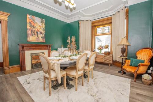 a dining room with a table and chairs and a fireplace at Elegant Escape, Modern Luxe in Historic Suite in Saint John