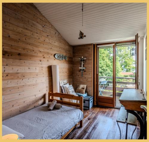 a bedroom with wooden walls and a bed and a window at La Marina I Maison T4 I Port Ripaille in Thonon-les-Bains