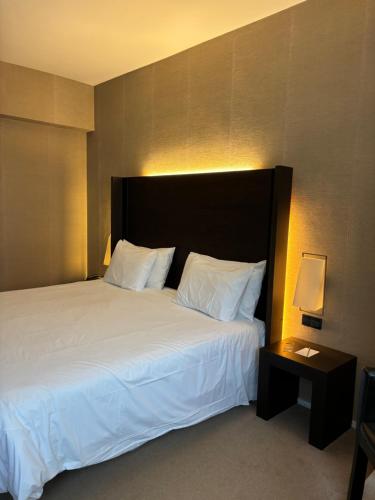 a hotel room with a large bed and a side table at Silken Gran hotel Durango in Durango
