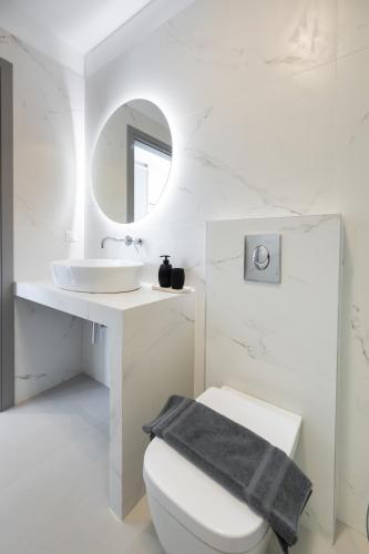a white bathroom with a toilet and a sink at Azzura villas in Vasiliki