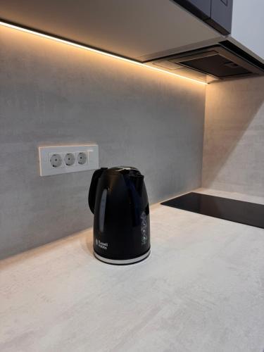 a black coffee pot sitting on a kitchen counter at Apartments Maritea in Vodice