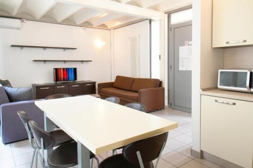 a kitchen and a living room with a table and chairs at APPARTAMENTO MODERNO con parcheggio gratuito di fronte in Lecco